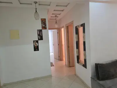 a hallway with pictures on the walls of a room at Appartement Meublé 2 Chambres avec Wi-Fi Haut Débit in Marrakech