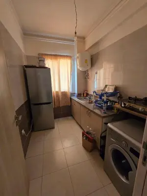 a kitchen with a refrigerator and a washing machine at Appartement Meublé 2 Chambres avec Wi-Fi Haut Débit in Marrakech