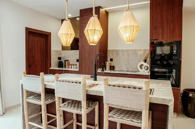 a kitchen with a kitchen island with chairs and lights at Luxury 4 bed apartment In the heart of Guilez! in Marrakech