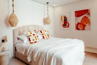 a bedroom with a white bed with orange and white pillows at Luxury 4 bed apartment In the heart of Guilez! in Marrakech