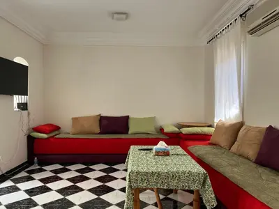 a living room with a red couch and a table at Duplex Marakech Dotea Lilia in Marrakech