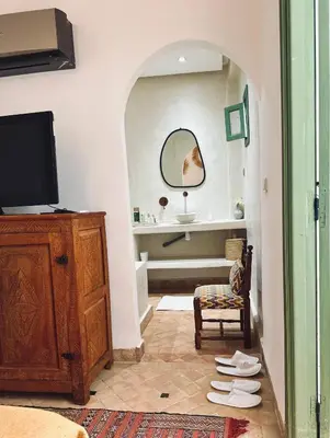 a bathroom with a sink and a tv in a room at Riad Baba in Marrakech