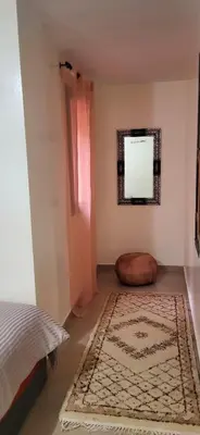 a bedroom with a bed and a rug and a window at Cozy Duplex in downtown Marrakesh- 7mn from Gueliz in Marrakech