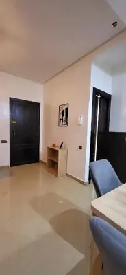 a living room with a black door and a table at Cozy Duplex in downtown Marrakesh- 7mn from Gueliz in Marrakech