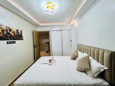 a bedroom with a bed with a stuffed animal on it at Appart Duplex 3ch Piscine in Marrakech
