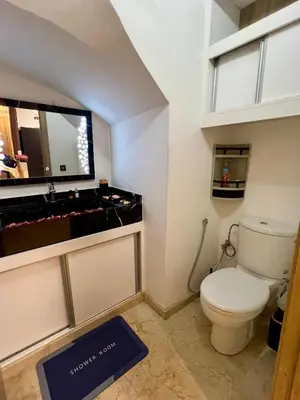 a bathroom with a toilet and a large mirror at Appart Duplex 3ch Piscine in Marrakech