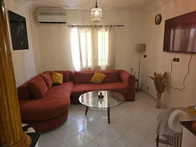 a living room with a red couch and a glass table at Machaalah gueliz in Marrakech