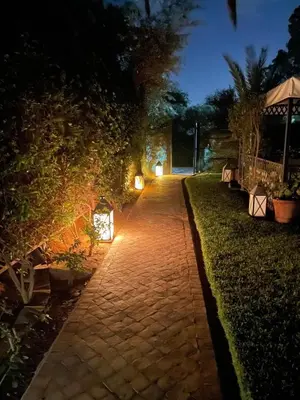 a brick pathway with lights on it at night at Casa Zitouni - Oasis with pool & private staff in Marrakech