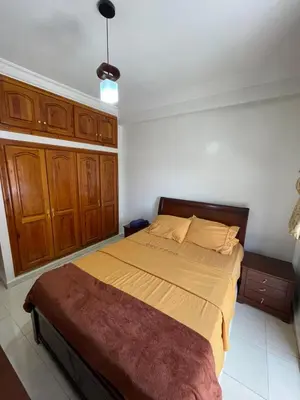 a bedroom with a large bed with wooden cabinets at Spacious 2 bedroom apartment 6 people 5 min from Marrakech center in Marrakech