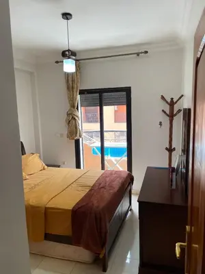 a bedroom with a bed and a view of a pool at Spacious 2 bedroom apartment 6 people 5 min from Marrakech center in Marrakech