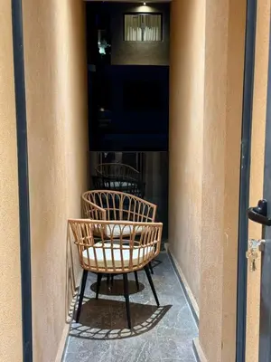 a wicker chair sitting on the side of a building at Marrakech Elite Garden, moderne, chaleureux, tout équipé in Marrakech
