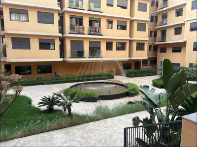 an apartment building with a fountain in the courtyard at Marrakech Elite Garden, moderne, chaleureux, tout équipé in Marrakech