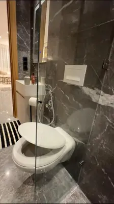 a bathroom with a toilet and a glass wall at Marrakech Elite Garden, moderne, chaleureux, tout équipé in Marrakech