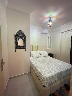 a bedroom with a bed and a chandelier at lUXEE APPARTEMENTN BELLE in Marrakech