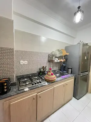 a kitchen with a stove and a stainless steel refrigerator at lUXEE APPARTEMENTN BELLE in Marrakech