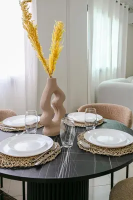a table with plates and glasses and a vase at Luxury apartment with pool in Marrakech