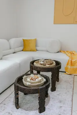 a living room with two tables in front of a couch at Luxury apartment with pool in Marrakech