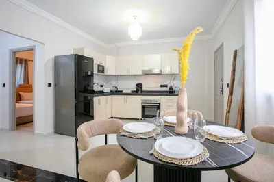 a dining room with a table with chairs and a kitchen at Luxury apartment with pool in Marrakech