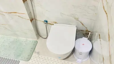 a bathroom with a white toilet in a corner at Luxury apartment 2 min Train Station 10 min Airport in Marrakech