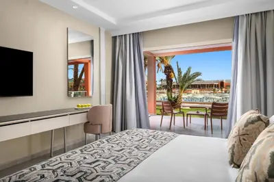 a bedroom with a bed and a television and a patio at Pickalbatros SUNGO Club - All Inclusive in Marrakech