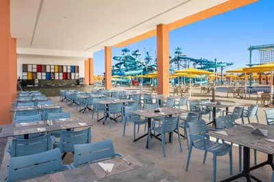 an outdoor patio with tables and chairs and a water park at Pickalbatros SUNGO Club - All Inclusive in Marrakech