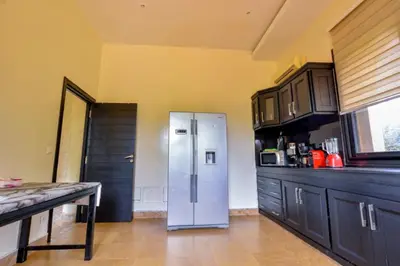 a kitchen with a stainless steel refrigerator and black cabinets at Luxury Villa in Marrakech