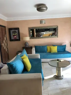 a living room with a blue couch and yellow pillows at Bel appartement central in Marrakech