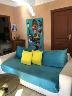 a blue couch with yellow pillows in a living room at Bel appartement central in Marrakech