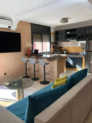 a living room with a couch and a kitchen at Bel appartement central in Marrakech