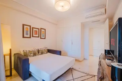 a bedroom with a white bed and a couch at Confort Spacieux a Hivernage 3 Chambres and Piscine in Marrakech