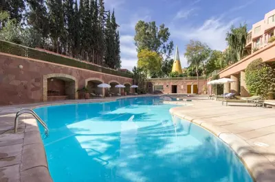 a large swimming pool with blue water at Confort Spacieux a Hivernage 3 Chambres and Piscine in Marrakech