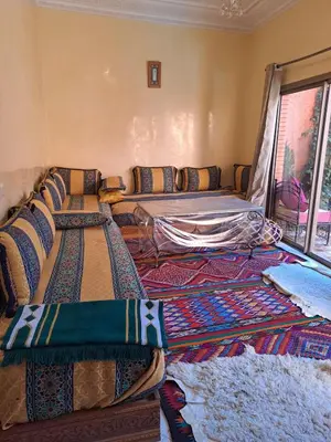 a living room with a couch and lots of pillows at Small villa with heated pool & garage for families in Marrakech