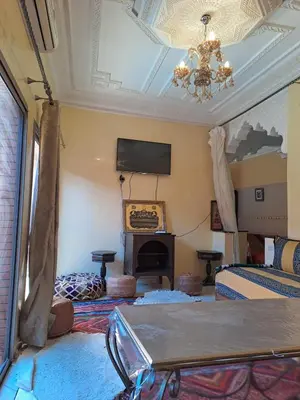 a living room with a fireplace and a chandelier at Small villa with heated pool & garage for families in Marrakech