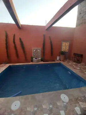 a swimming pool in the middle of a house at Small villa with heated pool & garage for families in Marrakech