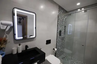 a bathroom with a shower and a sink and a mirror at La villa luxury suites in Marrakech