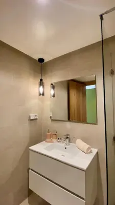 a bathroom with a sink and a mirror at Alba cosy - 3 piscines, Wifi HD, Parc de jeux in Marrakech