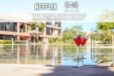 a wine glass sitting in the water next to a fountain at Alba cosy - 3 piscines, Wifi HD, Parc de jeux in Marrakech