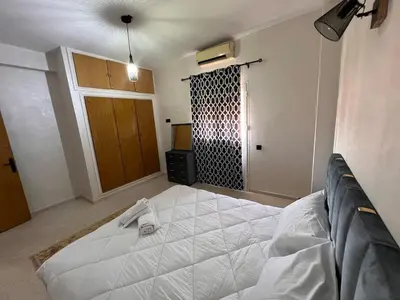 a bedroom with a large white bed and a door at Y&J Stay - Modern and Comfort in Marrakech