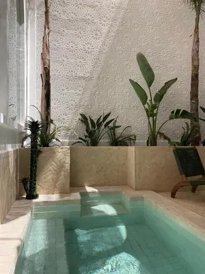 a swimming pool in the middle of a house at Private Riad Loulou Zitoun - rooftops - 2 pools - 4 rooms in Marrakech