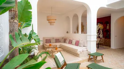 a living room with a couch and a table at Private Riad Loulou Zitoun - rooftops - 2 pools - 4 rooms in Marrakech