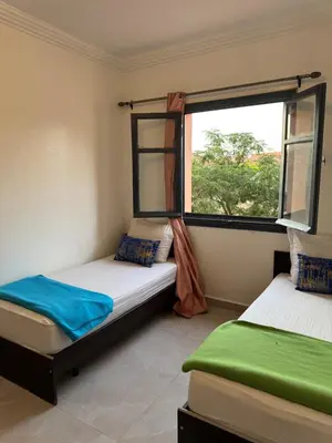 two beds in a room with a window at Golden palm appart in Marrakech