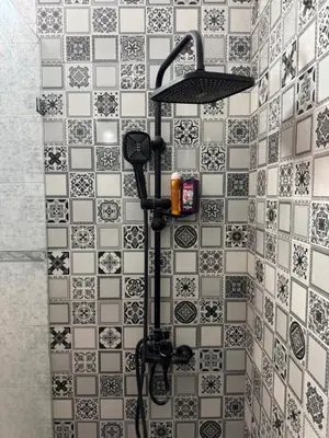 a shower with a black and white tile at Golden palm appart in Marrakech