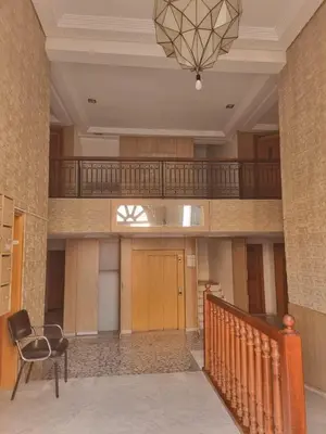 a hallway with a chair and a staircase in a building at Appartement Gueliz Carré Eden 90m2 idéalement placé in Marrakech