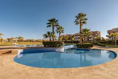 a large swimming pool with palm trees in a resort at Z Series Cozy and Modern Apartment in Marrakech