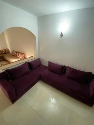 a living room with a purple couch and a mirror at Riad butterfly marrakech 2 in Marrakech
