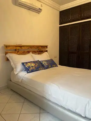 a white bed with two pillows in a room at Riad butterfly marrakech 2 in Marrakech