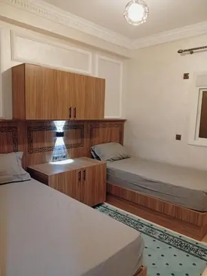 a bedroom with two beds and a lamp in it at Airport view apartment Marrakech in Marrakech