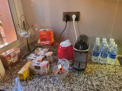 a counter top with a coffee maker and bottles of water at Airport view apartment Marrakech in Marrakech