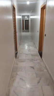 a hallway with a tile floor in a building at Beautiful apartment with children's pool in Marrakech