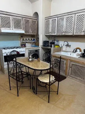 a kitchen with a table and chairs and a sink at Maristan Aicha Marrakech in Marrakech